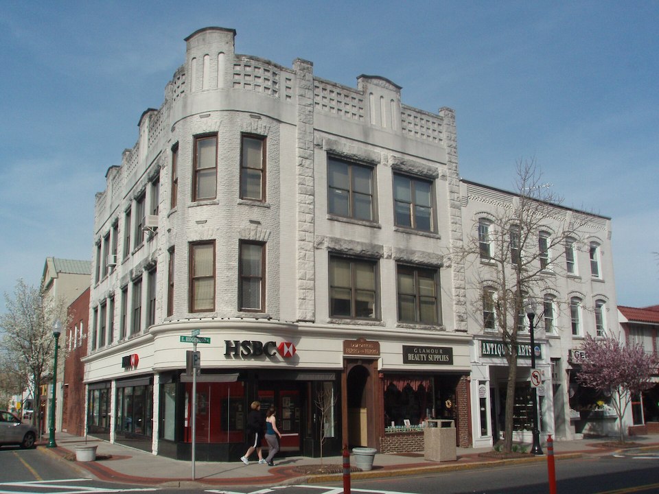 Historic commercial building with ground-floor shops at a street corner in Downtown Ridgewood, New Jersey.
